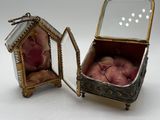 a small silver box with apples inside of it