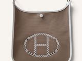 a brown purse with a white handle and a monogram on it