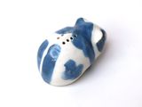 a small blue and white ceramic object on a white surface