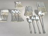 a lot of silver spoons and spoons on the table