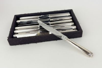 a silver knife in a black box on a white table