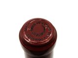 a close up of a bottle of wine on a white surface