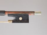 a close up of a violin bow with a piece of wood sticking out of it
