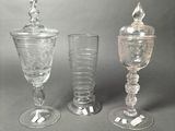 three glasses and a jar sitting on a table