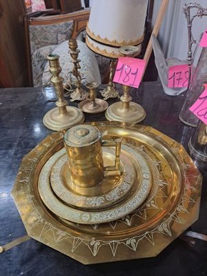 un plateau en or sur lequel est posée une bougie, posé sur une table