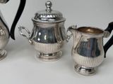 three silver teapots sitting next to each other on a table