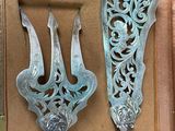 two silver spoons and a fork in a box