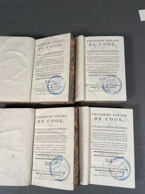 quatre vieux livres portant des timbres, posés sur une table