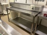 une grande table de travail en acier inoxydable dans une cuisine professionnelle