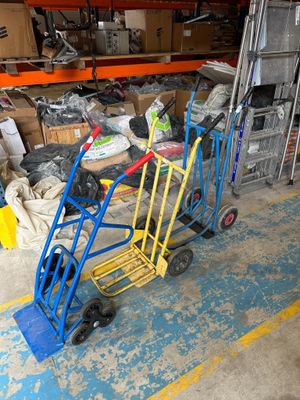 yellow and blue hand trucks are parked in a warehouse area