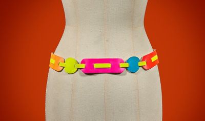 multicolored plastic belt on mannequin torso with orange background