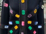 a mannequin sweater with colorful buttons and chains on it