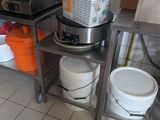 a kitchen with a stove, buckets, and a blender on the counter