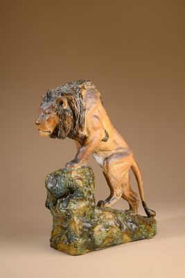 statue of a lion on a rock on a brown background
