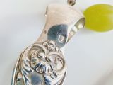 a silver spoon with a green bead and a silver spoon with a green bead on it