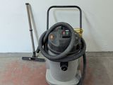 a vacuum that is sitting on the floor next to a broom