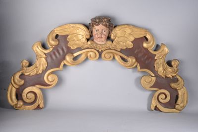 une statue d'ange au sommet d'une arche en bois