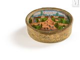 a small gold box with a picture of a city on it
