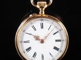 une montre de poche en or avec des chiffres romains sur le cadran