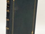 an old black book with gold trim and a gold border