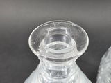 two clear glass vases sitting next to each other