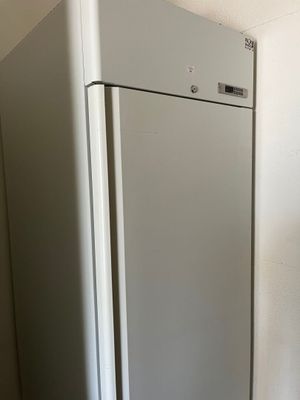 a refrigerator in the corner of a room with a white wall