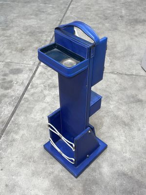 une photo d'une poubelle bleue posée sur un sol en béton