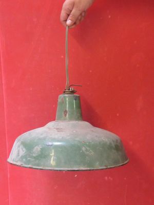 une personne tenant une lumière verte contre un mur rouge