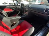 the interior of a car with red and black seats in a parking lot