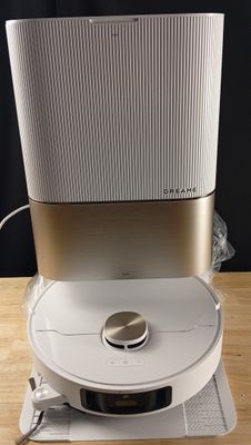 une enceinte blanche et dorée posée sur une table en bois