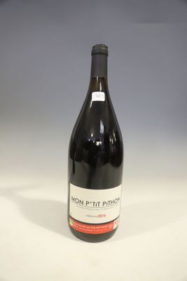 une bouteille de vin rouge posée sur une table blanche