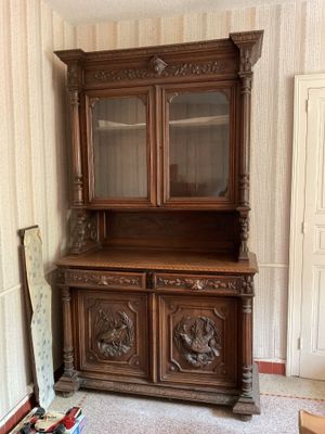 a wooden china cabinet in the corner of a room