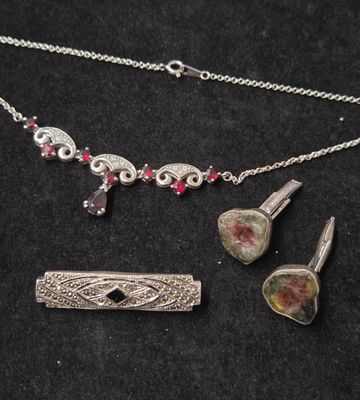 un gros plan d'un collier et d'une boucle d'oreille posés sur une surface noire