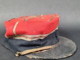 un chapeau rouge et noir posé sur un chapeau noir