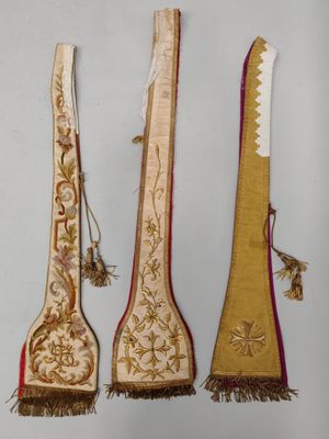 trois cuillères en bois ornées de motifs dorés et rouges et munies de pompons