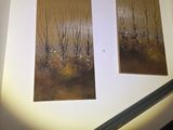 two paintings hanging on the wall above the stairs