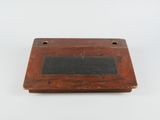 une vieille plaque en bois sur laquelle est fixée une ardoise noire
