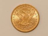 a close up of a gold coin on a white surface