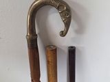 two old walking canes and a cane holder on a table