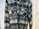 une chemise à carreaux gris et noirs suspendue à un portant