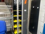 une chaise bleue posée à côté d'un support métallique muni de plateaux jaunes