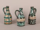 three green and white vases sitting next to each other on a table