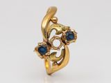 a close up of a gold ring with blue stones on it
