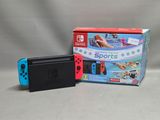 Nintendo Switch Lite avec un boîtier bleu et rouge et un emballage rouge et blanc
