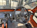 a steering wheel and dashboard of an orange vehicle