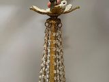someone is holding a gold plated candle holder with crystals on it