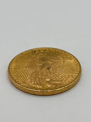 gros plan d'une pièce d'or sur une surface blanche