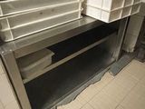 sol carrelé dans des toilettes publiques équipées d'un lavabo et d'étagères