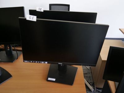 trois écrans d'ordinateur posés sur un bureau dans un bureau