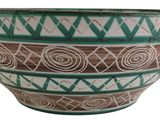a green and white bowl with a design on it